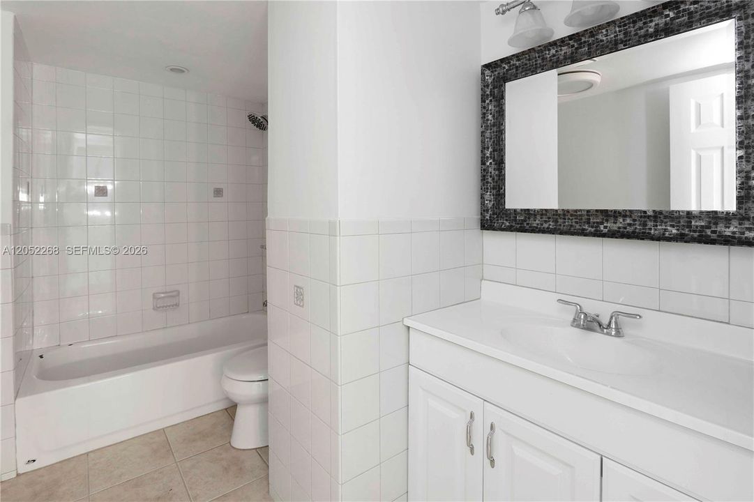 Baño completo en planta alta, impecablemente mantenido, con tocador de gran capacidad, amplio espejo decorativo y combinación de ducha y bañera, ideal para el confort de la familia
