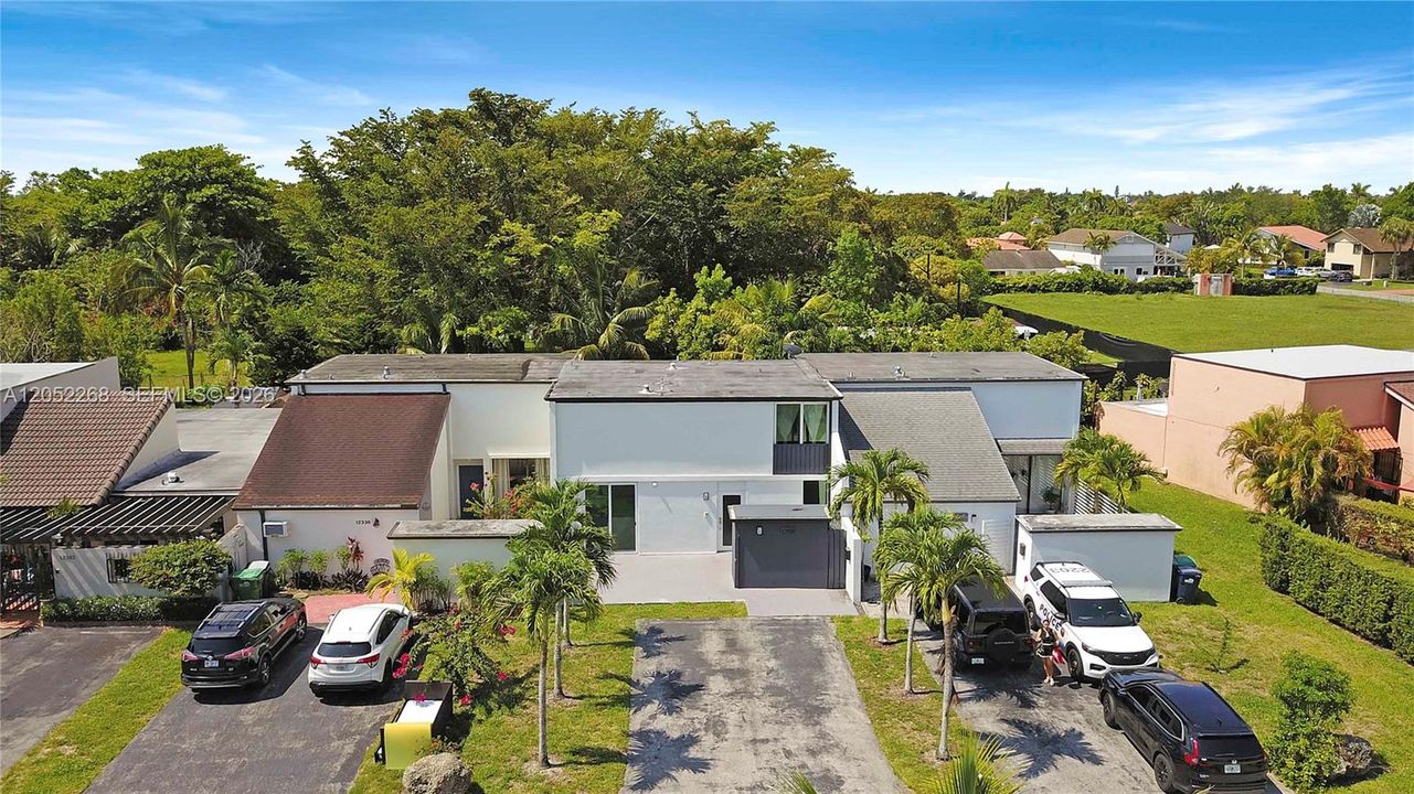 Vista aérea frontal de la propiedad, resaltando la fachada moderna, la amplitud del lote y el entorno residencial, ofreciendo una perspectiva clara de la ubicación y el potencial exterior de la unidad."