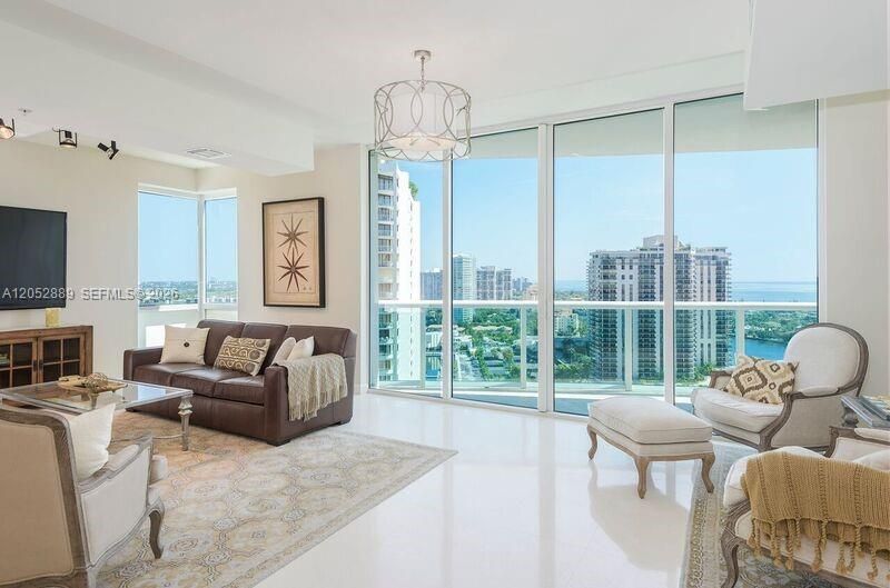 LARGE LIVING ROOM WITH HIGH CEILINGS, IMPACT FLOOR TO CEILING WINDOWS LEADING TO BALCONY. TAKE IN THOSE VIEWS!