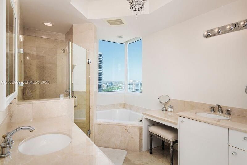 BEAUTIFUL MARBLE BATHROOM EVEN COMES WITH A VIEW! DOUBLE SINKS, MAKEUP AREA, TUB, SHOWER, AND WATER CLOSET FOR PRIVACY.