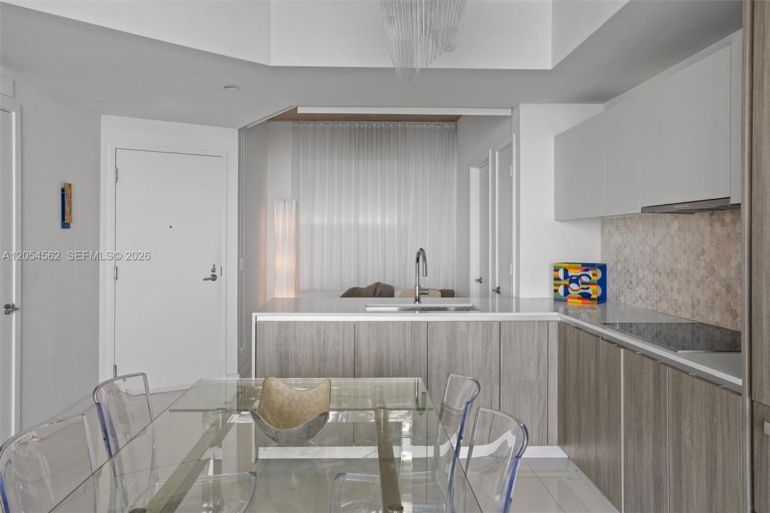 Contemporary kitchen with breakfast seating and integrated Miele appliances