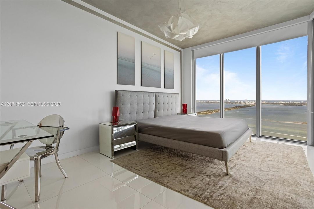 Second bedroom with lounge seating and tranquil bay views, fully furnished