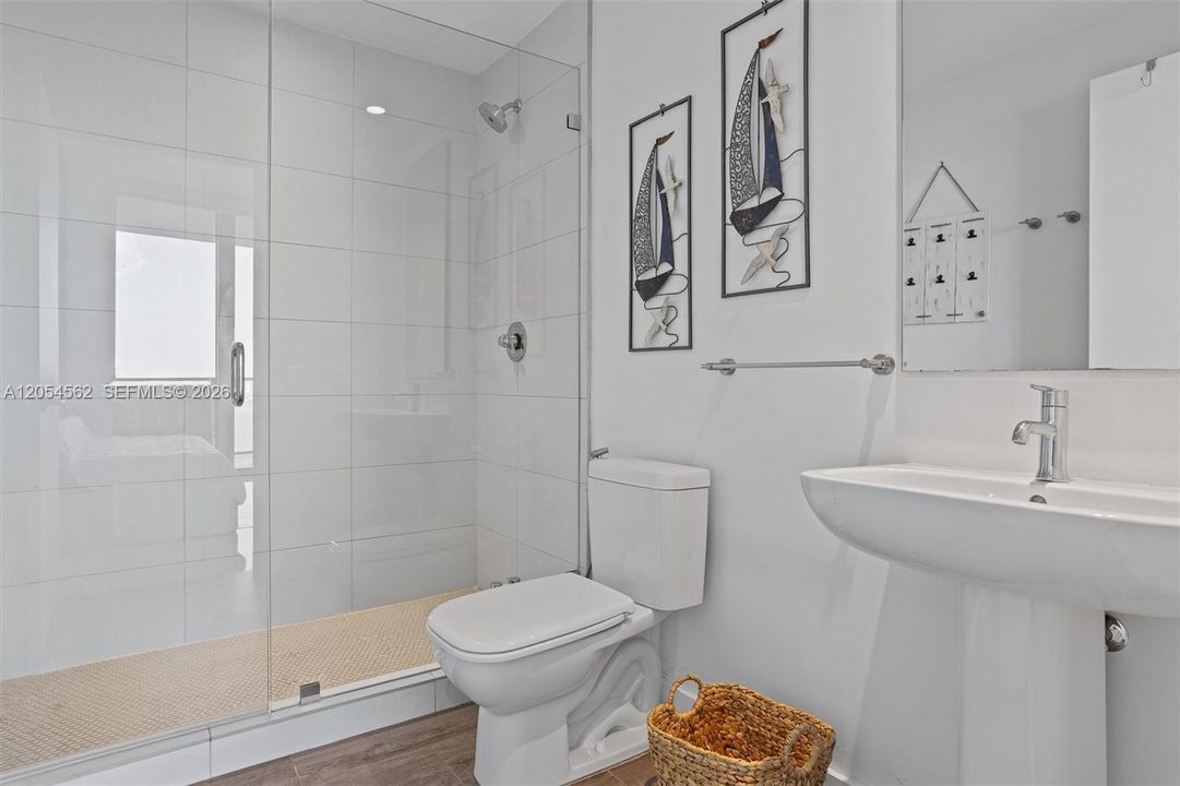 Full guest bathroom with pedestal sink and bright natural light