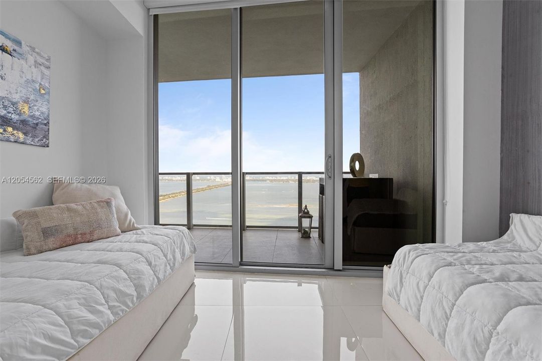 Serene bedroom with terrace access and calming Biscayne Bay views