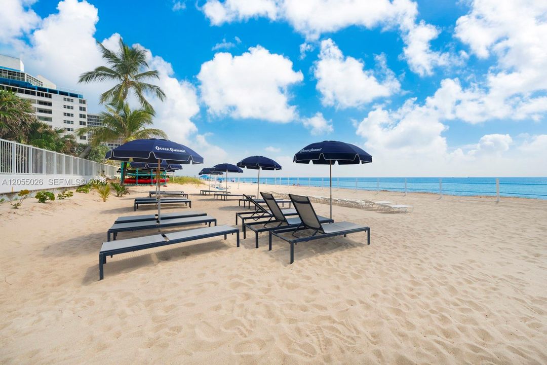 Building open beach area w chaise and umbrellas