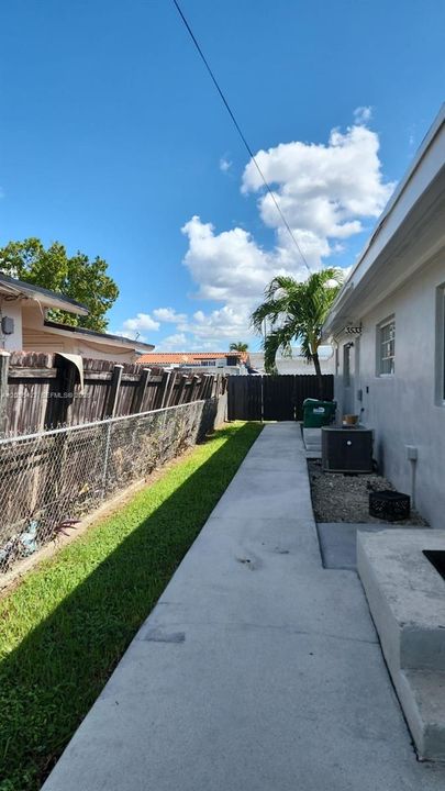 Acceso privado independiente: Un pasillo lateral de concreto, limpio y bien delimitado, ofrece un acceso privado y cómodo desde el área de estacionamiento directamente hasta la entrada del estudio. Esta disposición asegura total autonomía y tranquilidad para el residente