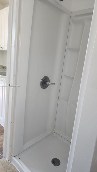 Baño moderno y funcional: Un espacio impecablemente diseñado que combina limpieza y modernidad. Esta vista permite apreciar la fluidez del diseño hacia la sala de estar, destacando la excelente distribución de la unidad y la atención al detalle en cada área para ofrecer una experiencia cómoda y práctica.