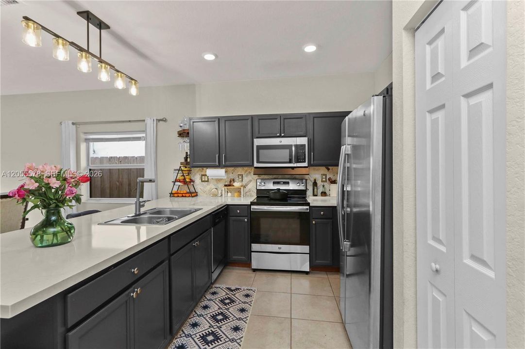A chef’s delight! This modern kitchen features sleek dark cabinetry, elegant countertops, and stainless steel appliances, offering a sophisticated space that is as functional as it is beautiful.