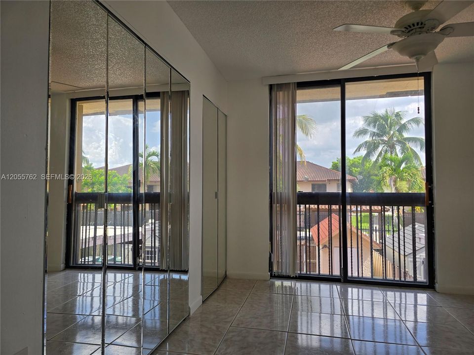 Primary bedroom with balcony looking the community pool.