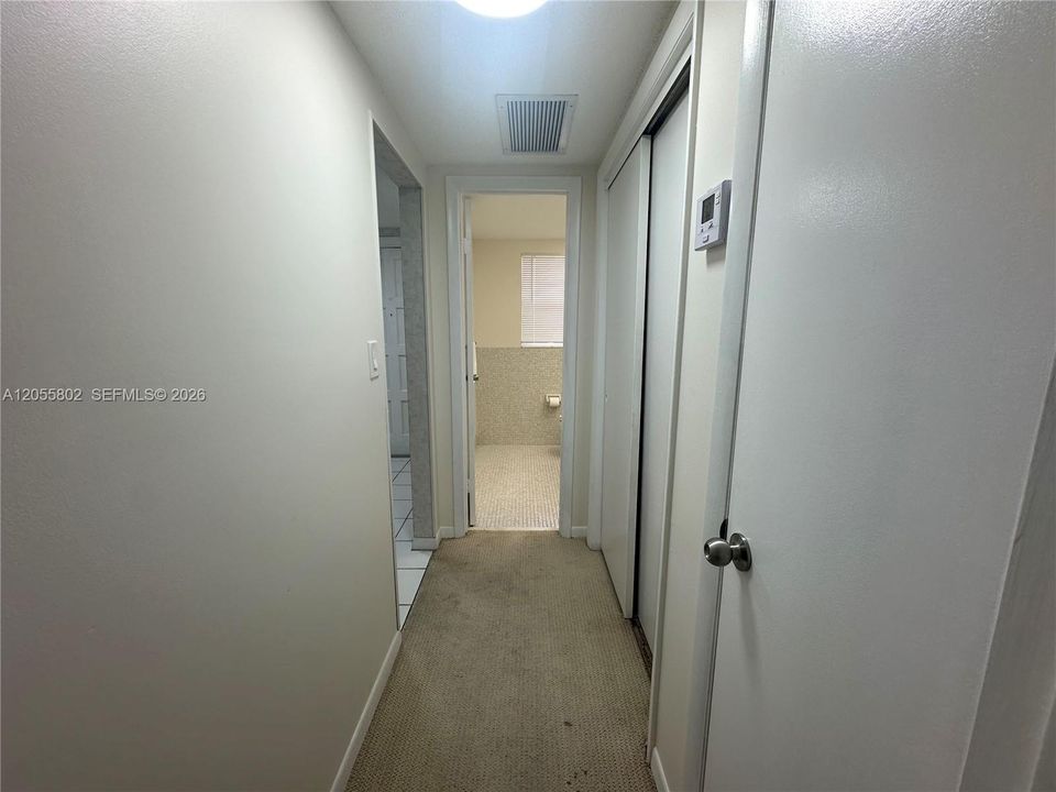 Hallway to Half Bathroom and Primary Bedroom