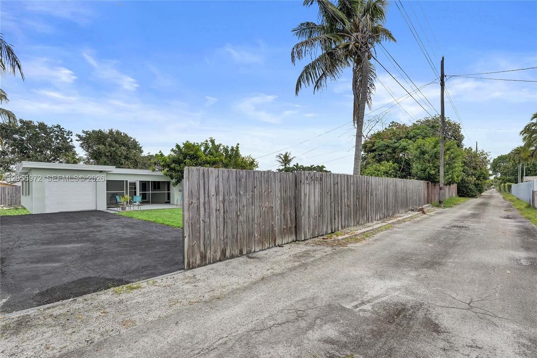 Alley in rear of home with entrance to driveway and garage