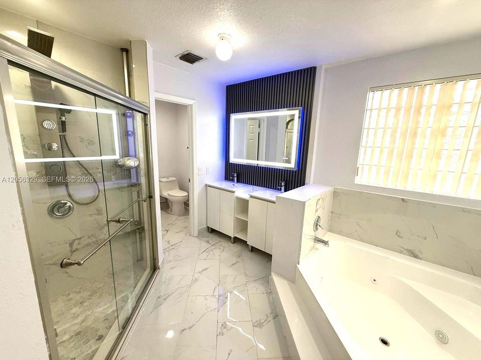 REMODELED PRIMARY BATHROOM WITH TUB AND SHOWER