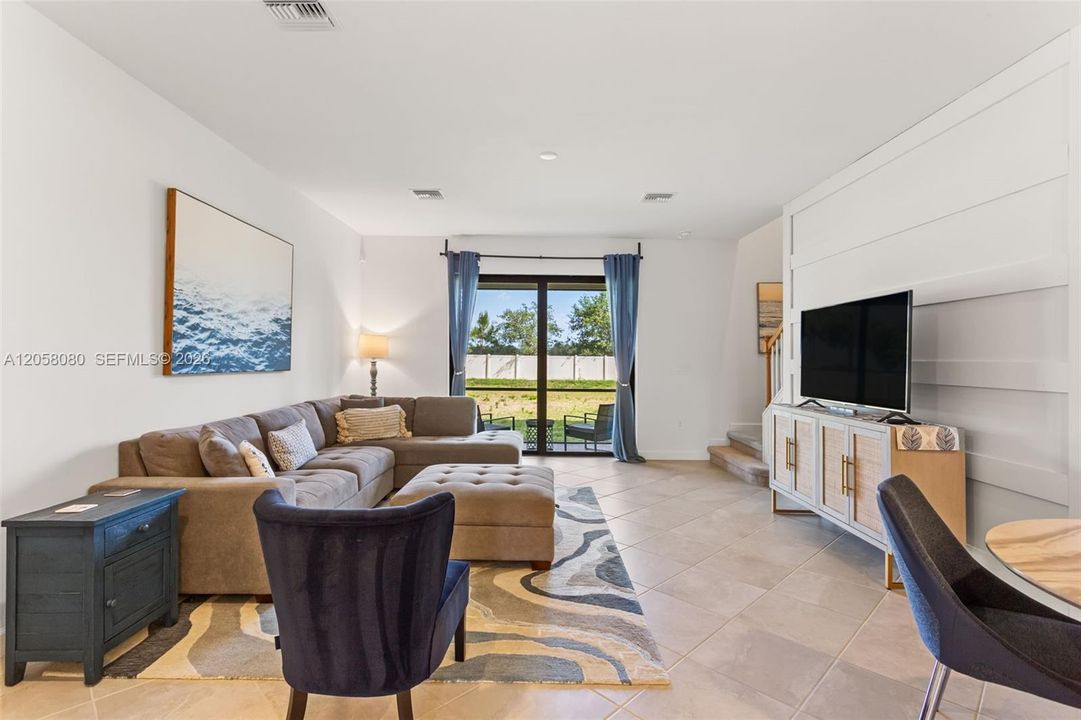 The open-concept main level is adorned with durable tile flooring and filled with natural light