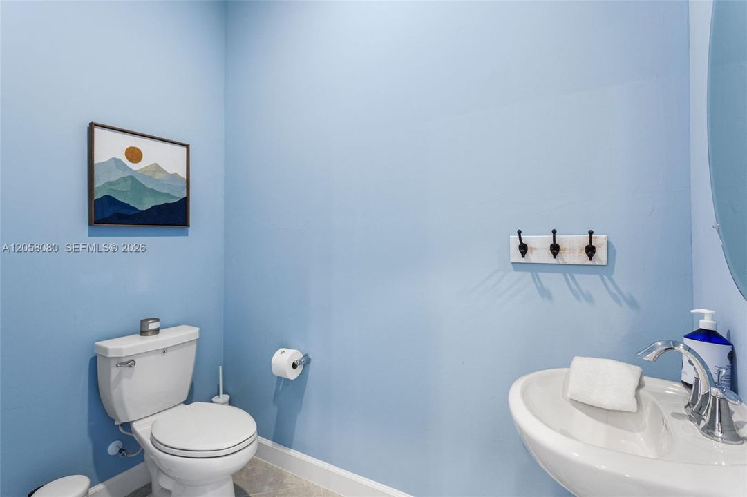 Convenient half bathroom located near the main entrance, perfect for guests