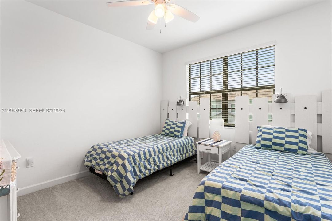 Two generous guest bedrooms at the front of the home are thoughtfully decorated with beach-themed accents, creating a welcoming coastal vibe
