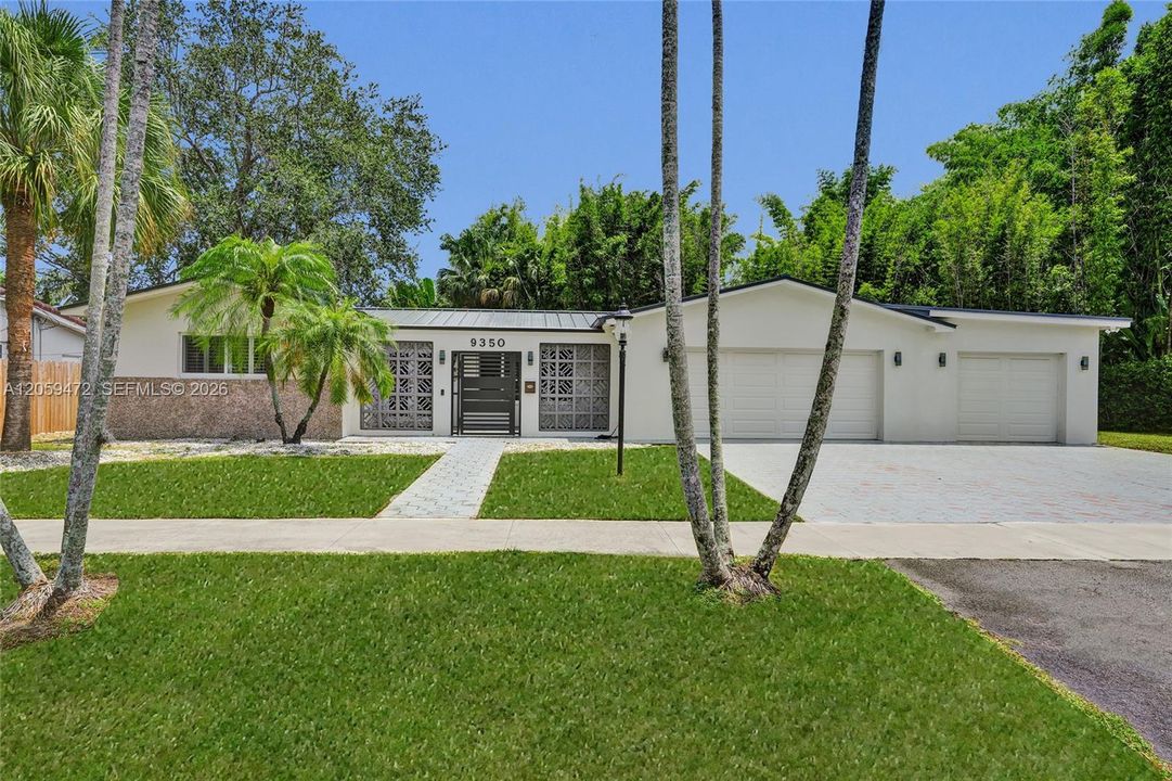 Beautifully landscaped exterior with mature palm trees, manicured lawn, and a welcoming curb appeal.