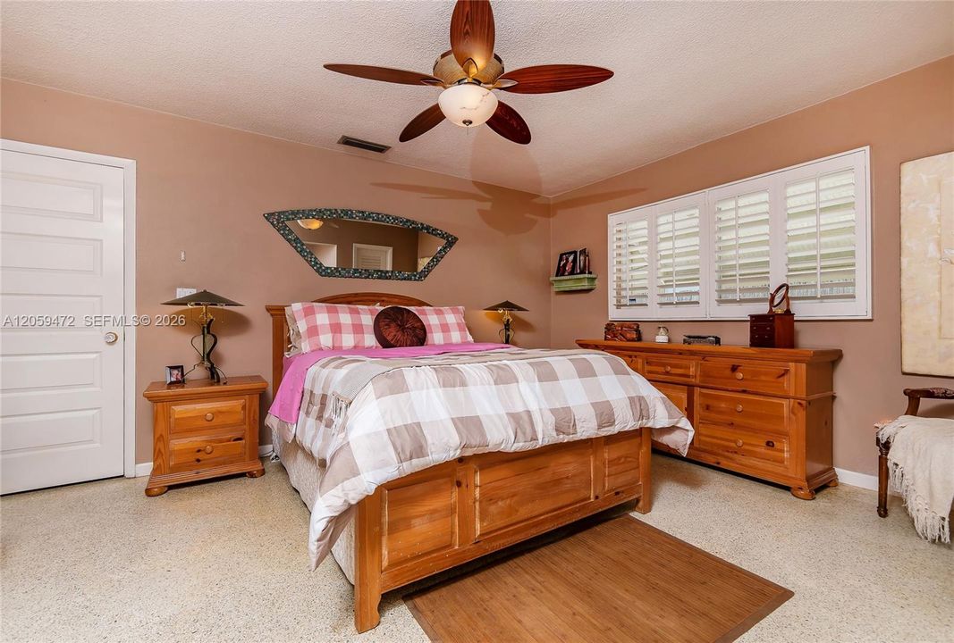 Master bedroom retreat featuring a ceiling fan, generous windows, and classic wood furnishings.  FYI - Some paint colors have changed since the last pictures.  Furniture, some lighting fixtures  & personal items not included in the rental, Cedar-lined closet
