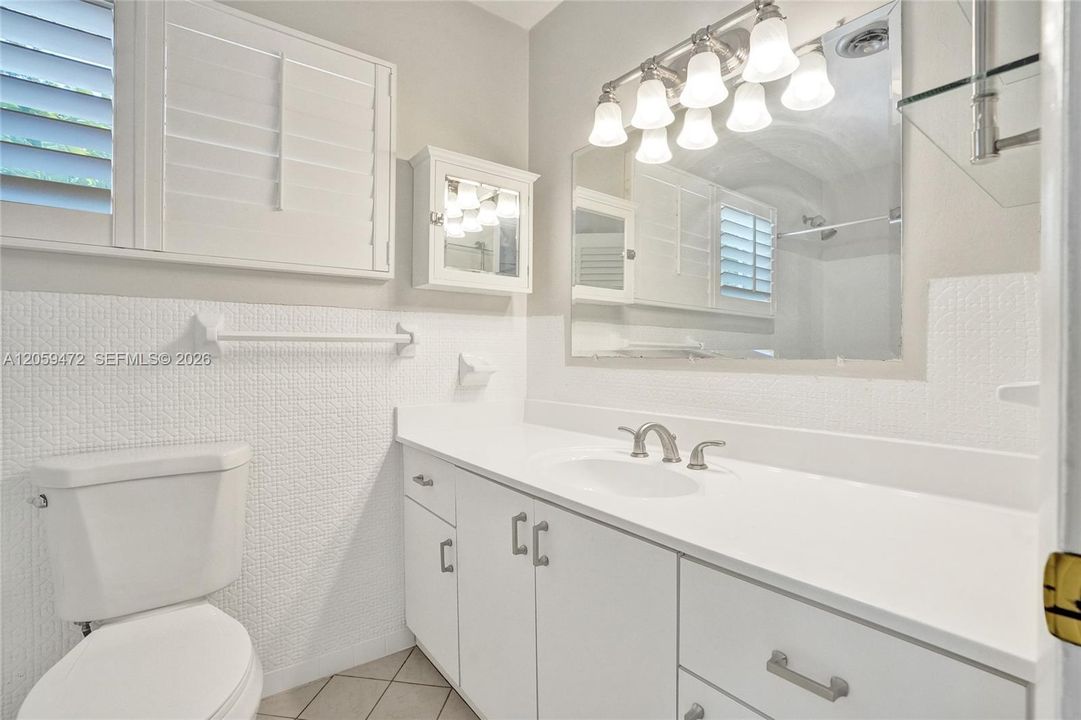 White master bathroom features abundant natural light, IMpact windows, and Plantation shutters.