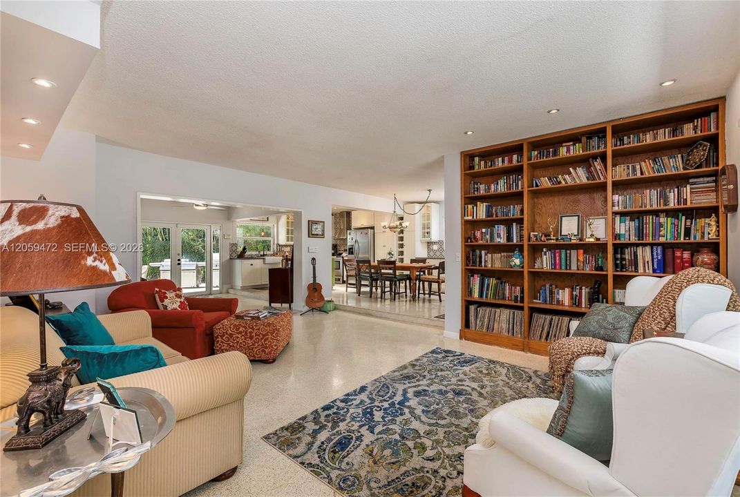 Spacious living area anchored by floor-to-ceiling built-in bookshelves, offering both style and functional storage in a light-filled setting.Color scheme is now fresh white throughout. Furniture, personal items, and some lighting fixtures not included.