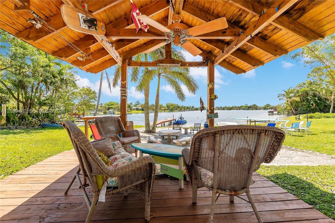 Covered outdoor dining pavilion overlooking the lake, offering a shaded spot to relax and take in the water views. Furniture not included