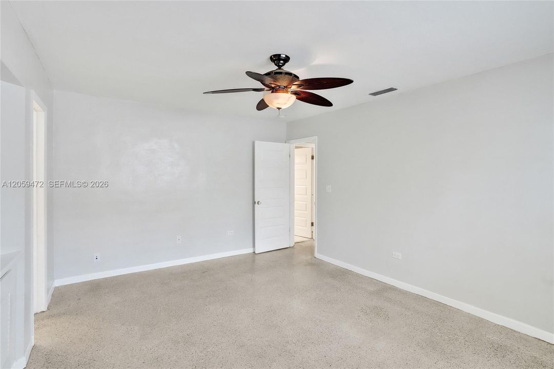 Bright bedroom with cedar-lined closet space and ceiling fan for added comfort.