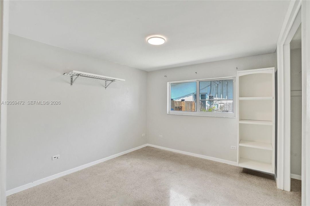 Spacious bedroom, mpact windows, light colors, & terrazo floors..