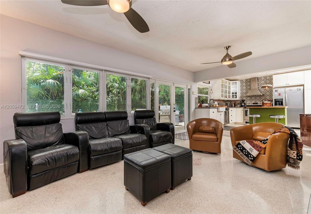 Comfortable family room with theater-style leather seating and ceiling fan, offering a cozy retreat for movie nights or relaxing evenings.  FYI - Some paint colors have changed since the last pictures.  Furniture, some lighting fixtures  & personal items not included in the rental