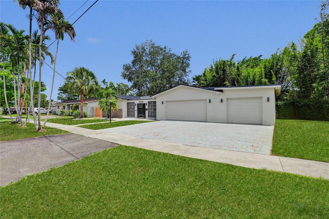 Boasts a rare, three-car garage and manicured curb appeal, framed by mature palms and a spacious driveway. Tropical living at its best on a huge, motorized lake.