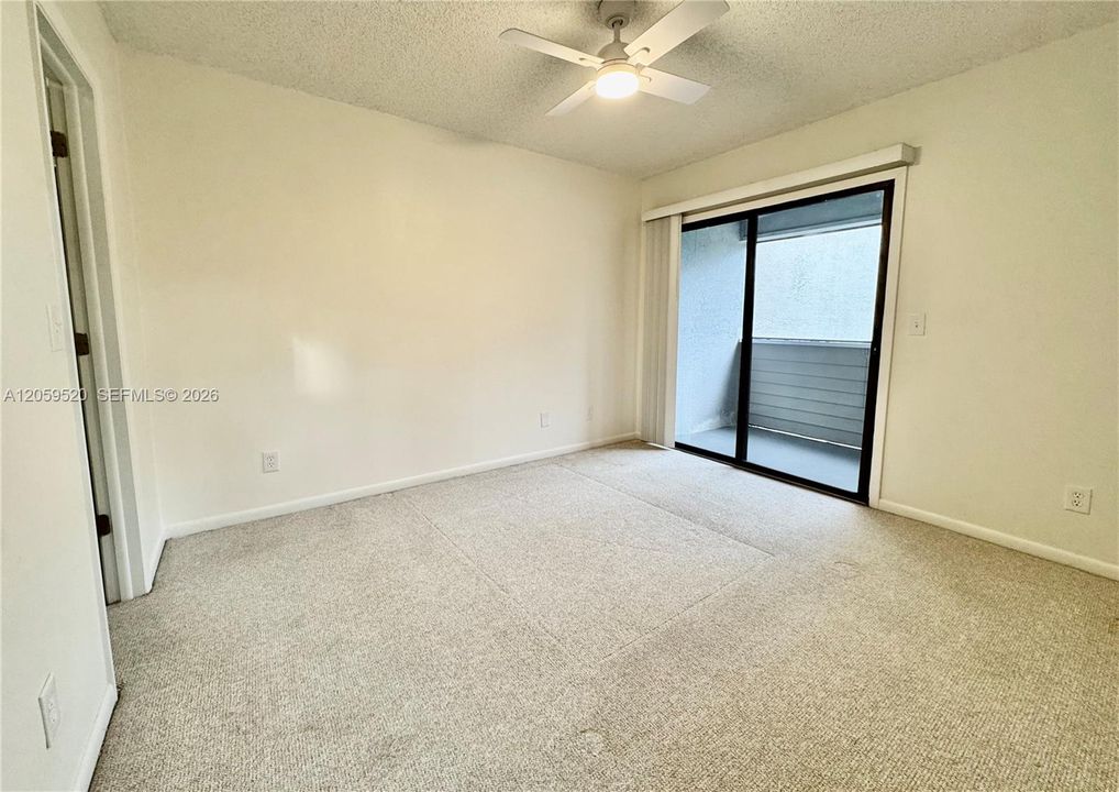 Primary bedroom with a private balcony and large walk in closet
