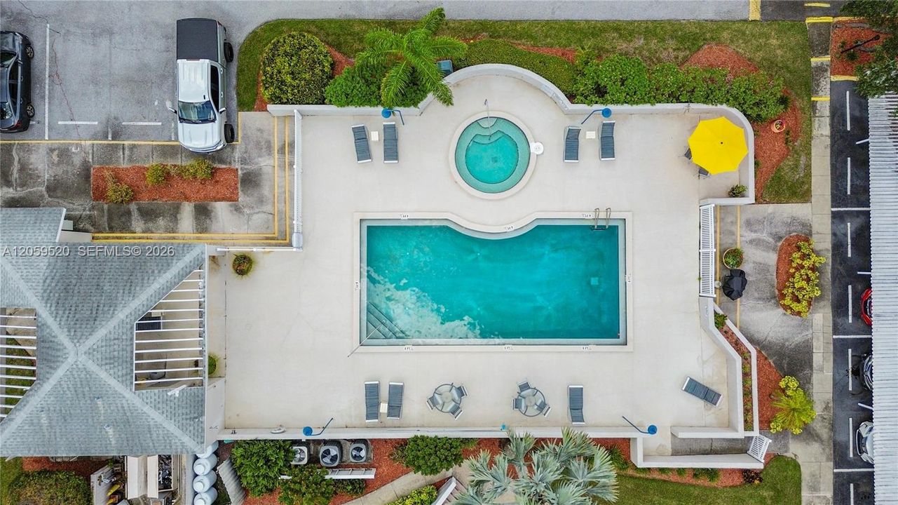 Community pool and spa with a BBQ grill station.