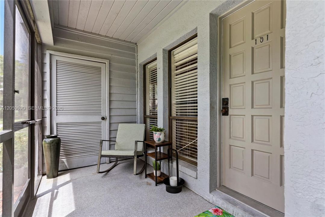 Entrance of unit featuring a screened-in porched and an exterior storage closet