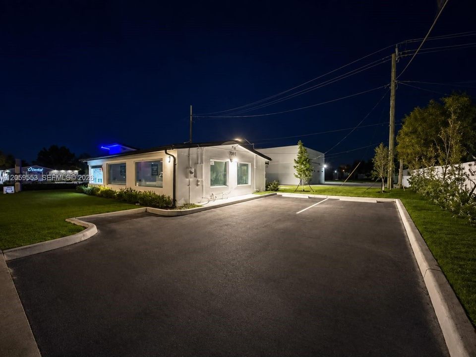 Professional exterior with illuminated façade and parking.