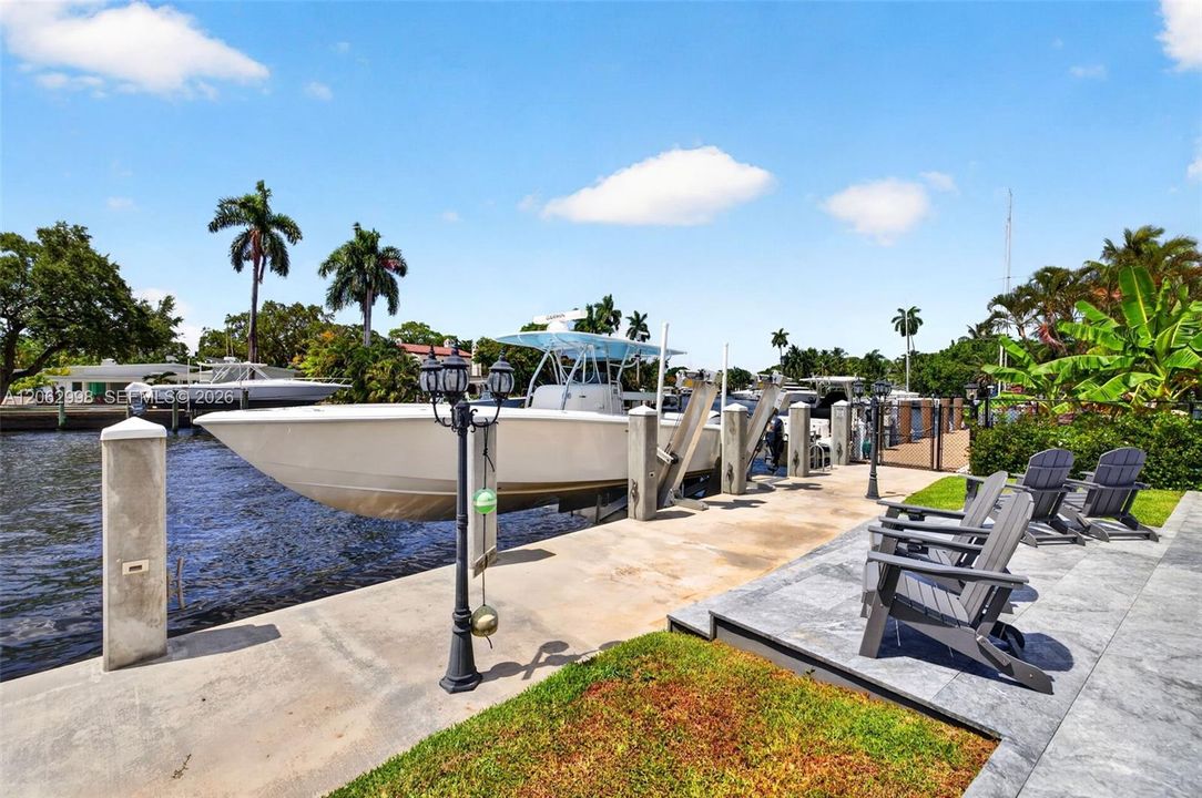 View from the new concrete dock and seawall to the Salt chlorinated pool w/ water features, LED color changing light, sun shelf with umbrella hole and in water stools. Stone decking surrounds the pool