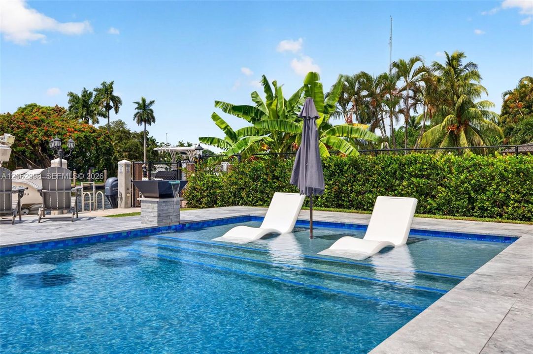 Covered patio w/ T&G ceilings, fans, fire pit seating and outdoor kitchen overlooks the gorgeous wide New River views and pool area