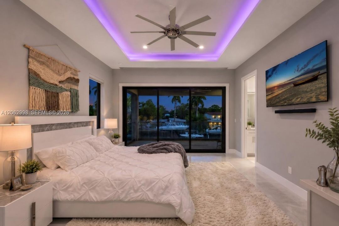 Primary bedroom suite w/ french doors, morning bar, en suite walk in closet and spa bathroom. Sliders lead to private balcony looking down the river