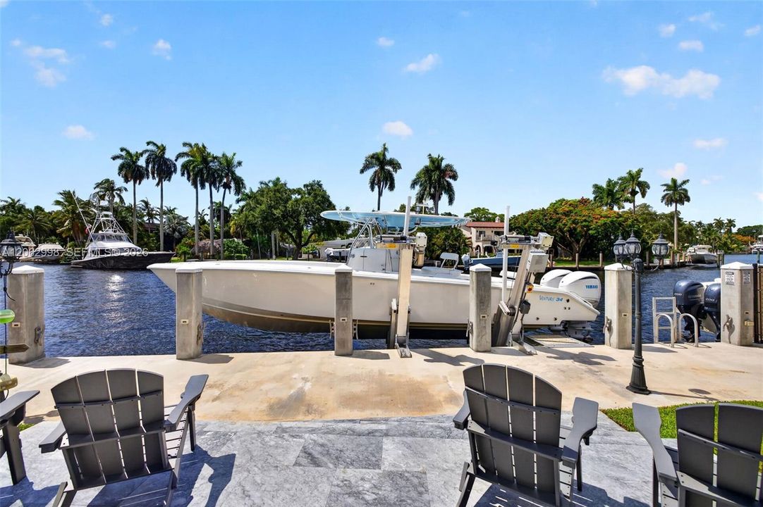 View from the new concrete dock and seawall to the Salt chlorinated pool w/ water features, LED color changing light, sun shelf with umbrella hole and in water stools. Stone decking surrounds the pool