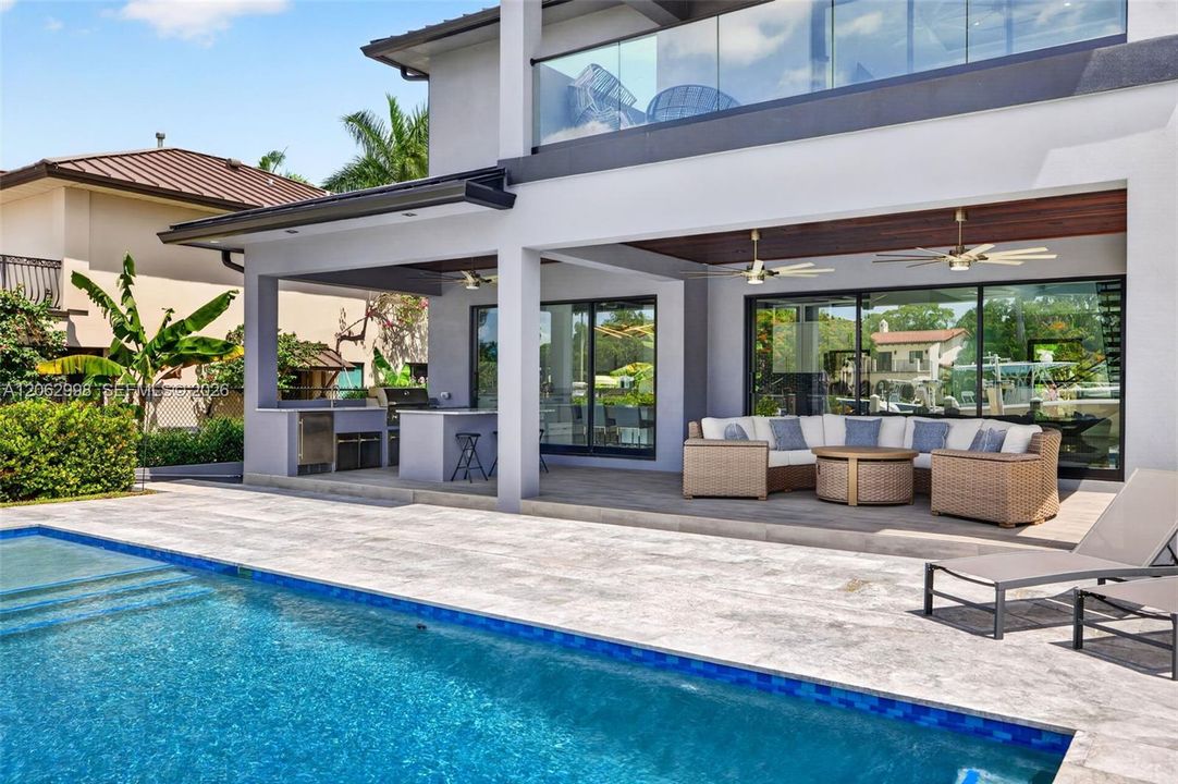 Covered patio w/ T&G ceilings, fans, fire pit seating and outdoor kitchen overlooks the gorgeous wide New River views and pool area