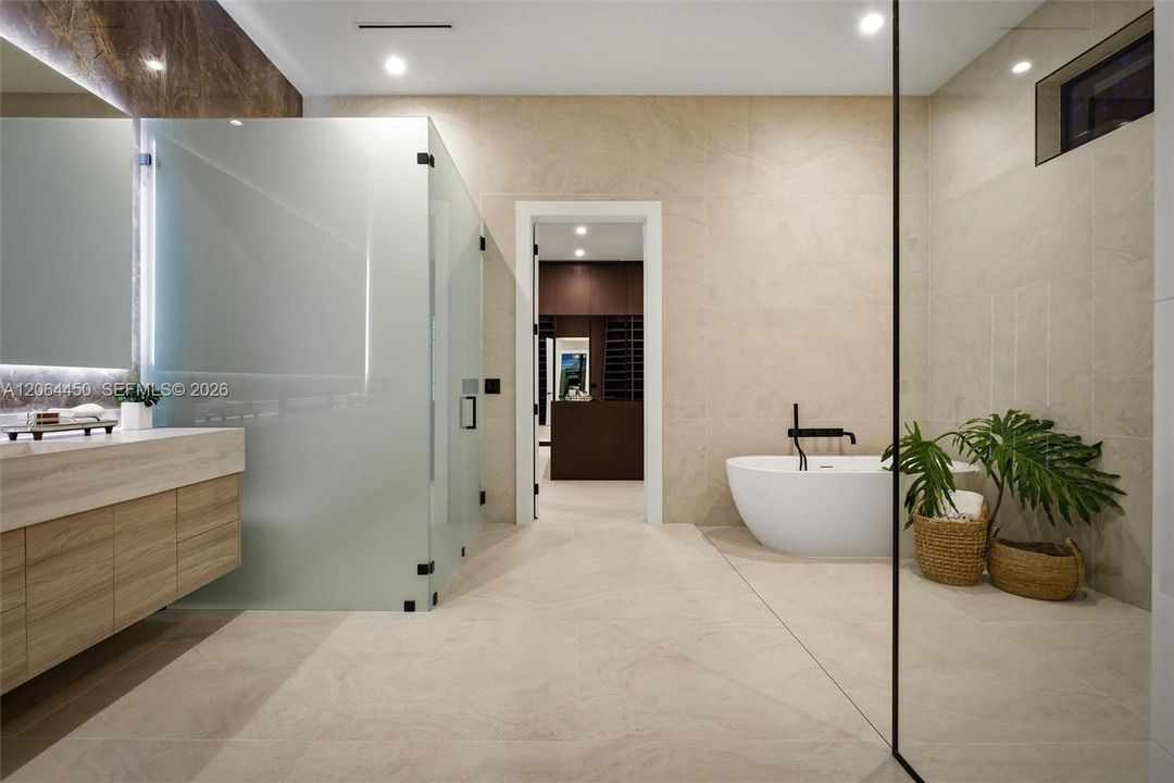 Spa inspiring primary suite bathroom with glass panel shower