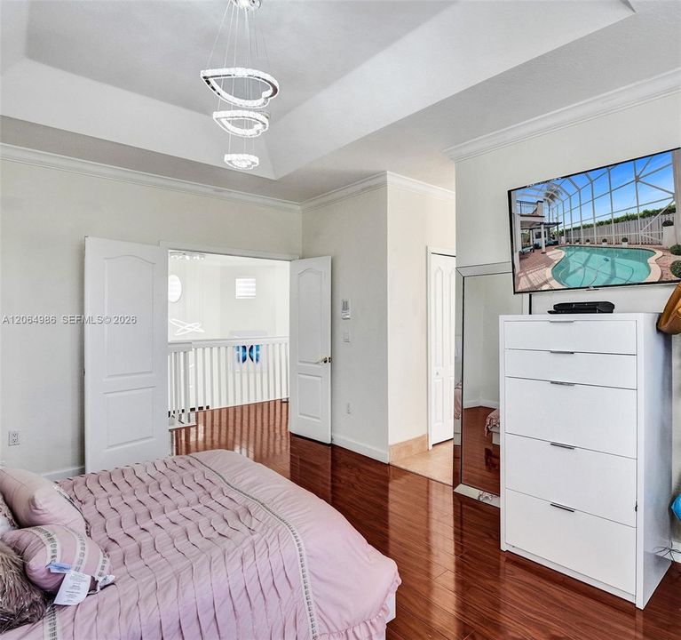 MASTER BEDROOM WITH CHANDELIER AND OUBLE DOORS LEADING TO LOFT