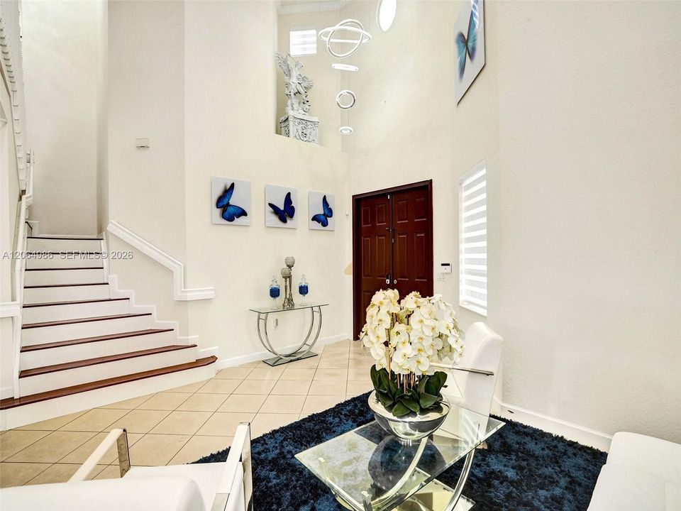 ELEGANT ENTRY AND LIVING AREA WITH VERY HIGH CEILINGS AND SPECTACULAR CONTEMPORARY GEOMETRIC CHANDELIER.