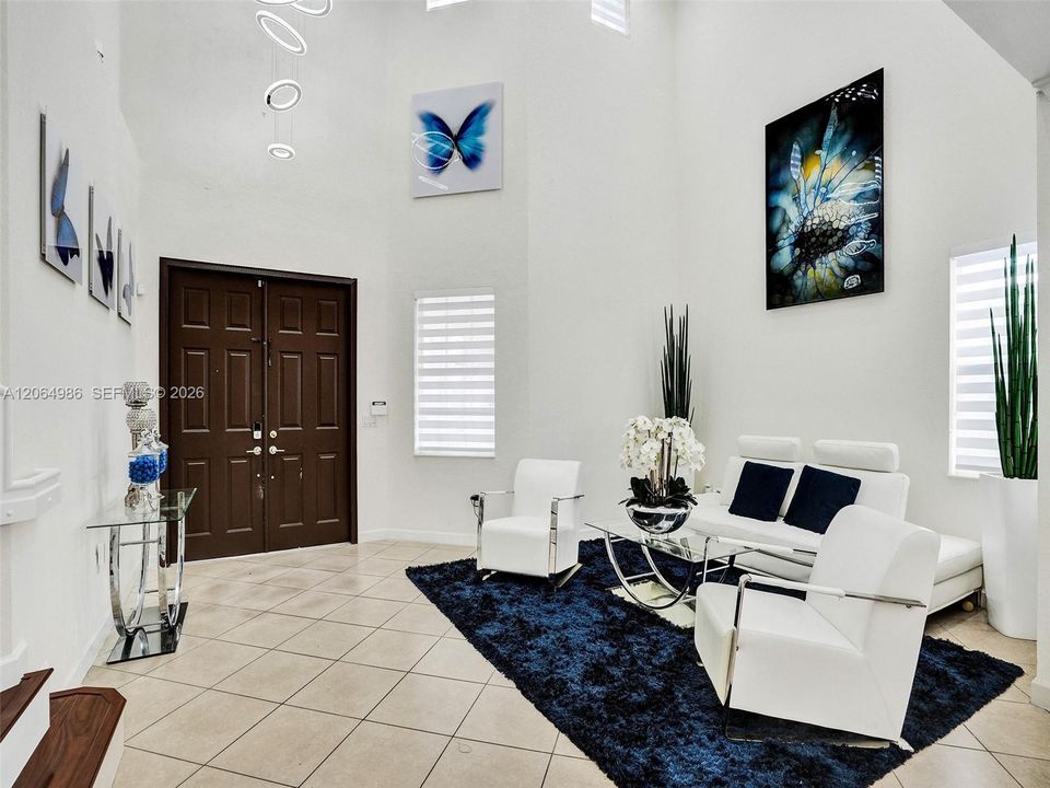 ELEGANT ENTRY WITH VERY HIGH CEILING AND CONTEMPORARY GEOMETRIC CHANDELIER.