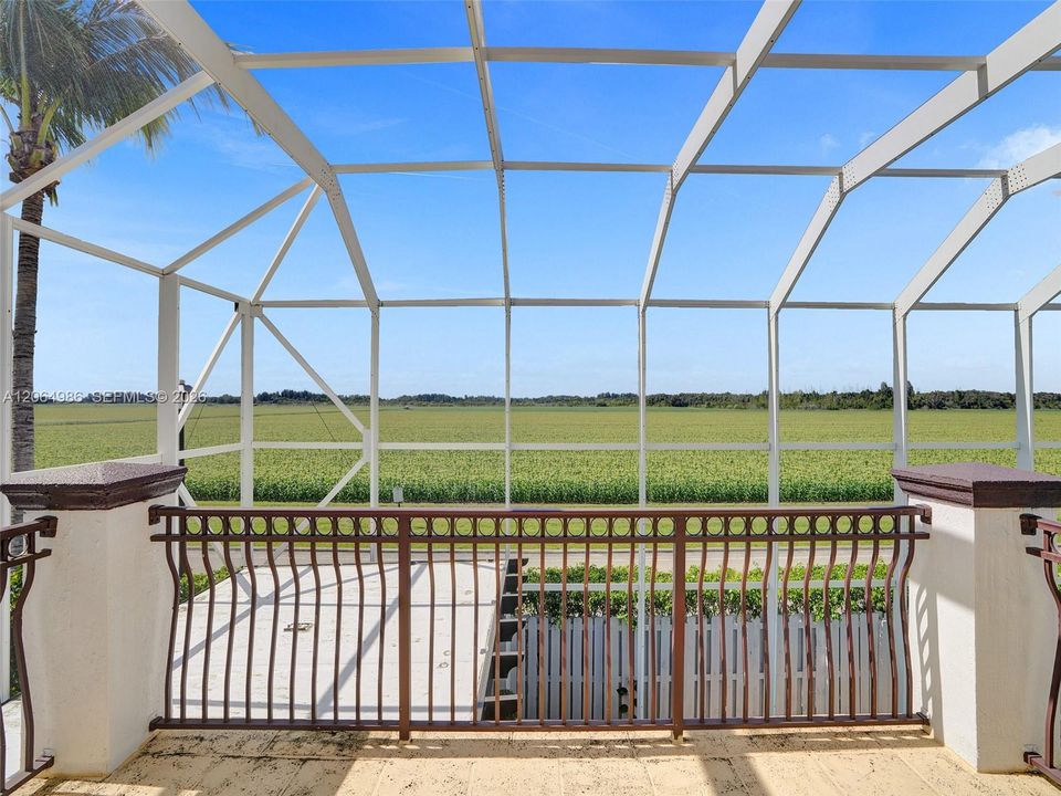 SCREENED BALCONY OVERVIEWING POOL AND OPEN FIELD TO ENJOY BEAUTIFUL ROMANTIC SUNSETS.
