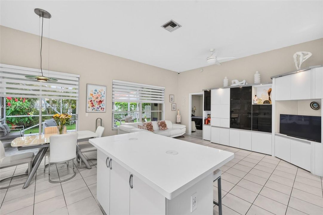 Spacious open concept kitchen w/ built in wall unit, volume ceilings and solid surface counters