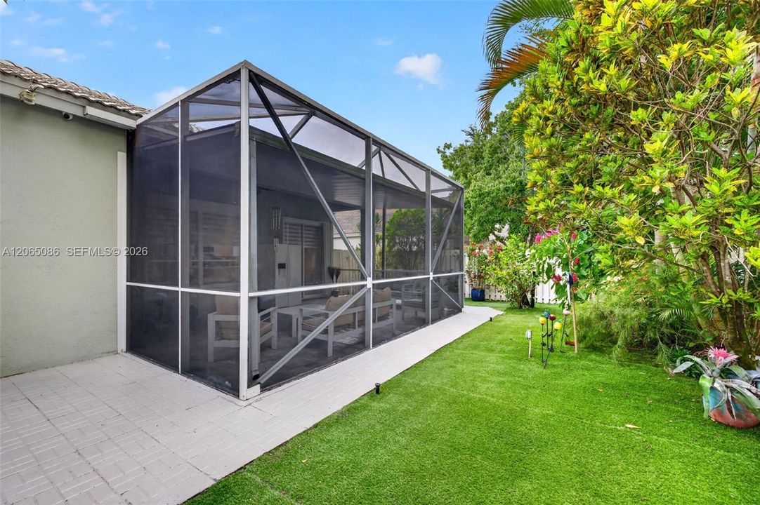Step outside to your large, fully tiled, screened-in patio with a covered overhang overlooking a fully fenced backyard with mature fruit trees, astroturf and a Rain Bird irrigation system.