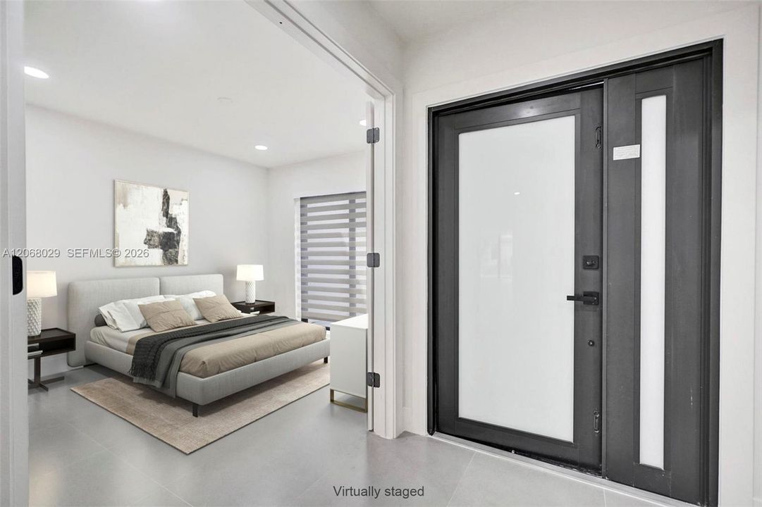 Third bedroom, virtually staged, with private access to front patio. Also shown front entry hurricane proof new door.