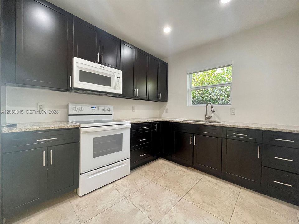 Remodeled kitchen with granite countertops and new cabinets.