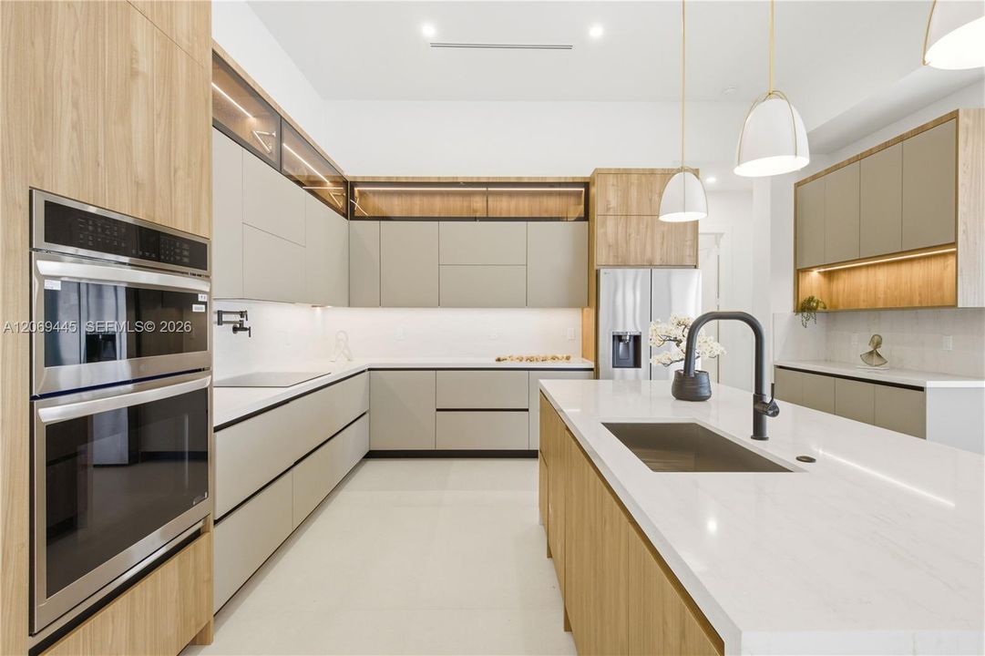 Sleek European-style cabinetry with warm wood accents and integrated LED lighting creates a sophisticated modern aesthetic.