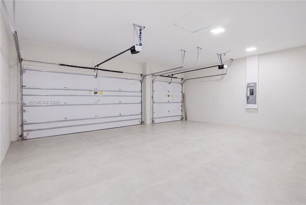 Spacious tiled 3-car garage offers a clean, polished finish with ample room for vehicles and storage.