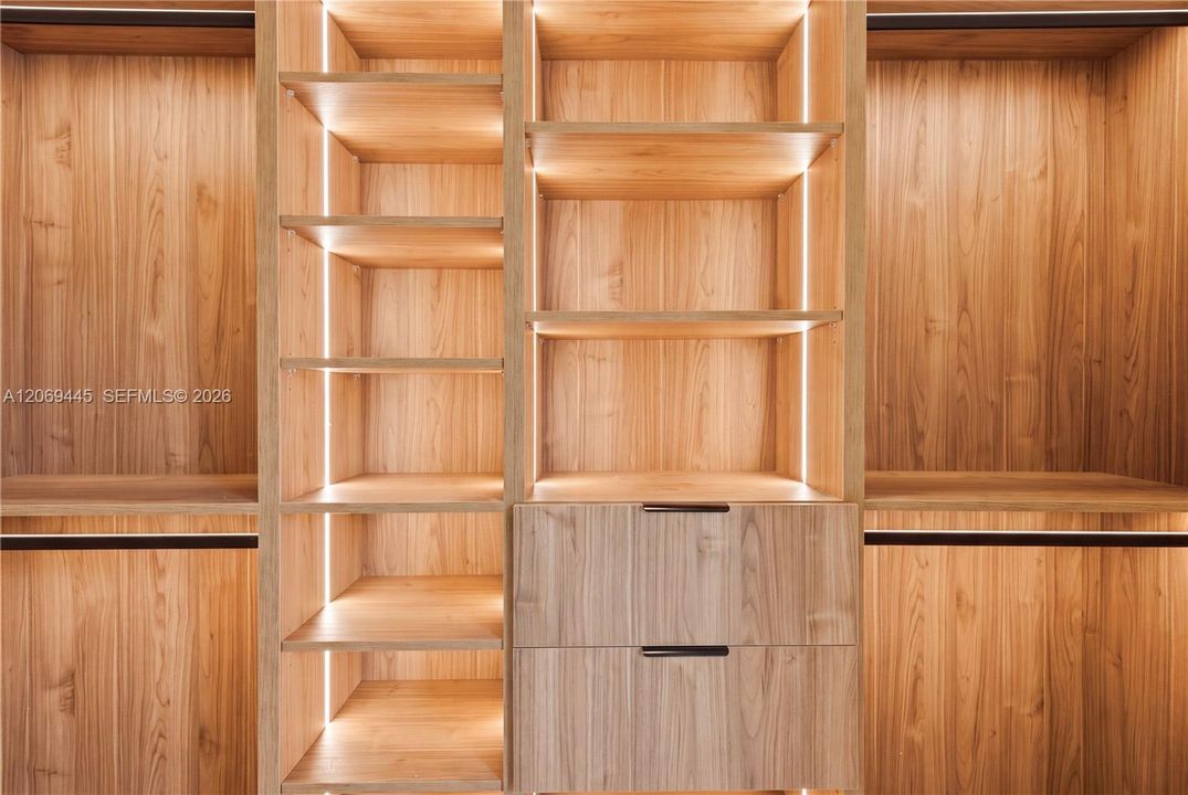 Integrated LED lighting and built-in drawers elevate the closets with a luxurious boutique-style feel.