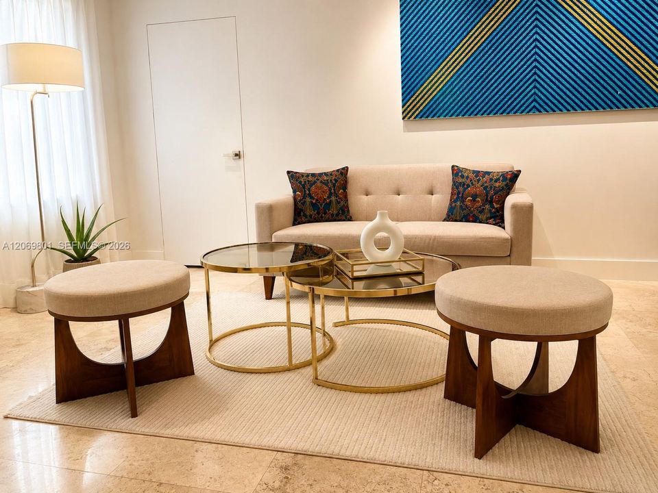Elegant sitting area that enhances the home's expansive open-concept design. Surrounded by marble floors, soaring open spaces, and abundant natural light, this versatile lounge creates a warm and inviting setting for conversation, reading, or relaxing. Beautifully integrated with the formal dining room and main living areas, it adds both sophistication and functionality while preserving the home's bright, airy feel.